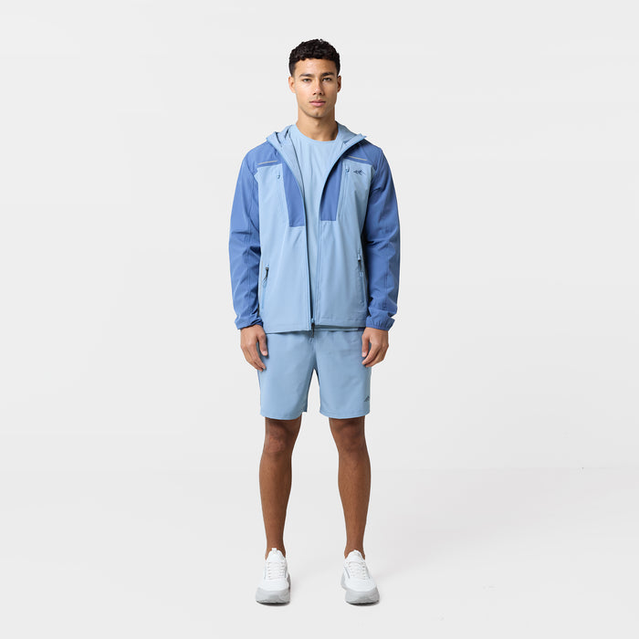 The model is wearing the Closure tri-set with matching light blue tshirt, shorts and windbreaker with pockets