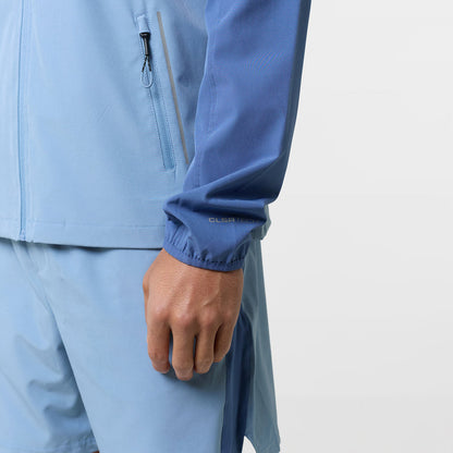 Close up of the logo on the cuff of the light blue windbreaker tri-set
