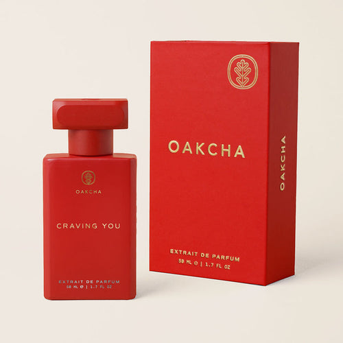 Front view of Craving You perfume bottle and red box showing matte rectangular bottle with gold logo on beige background