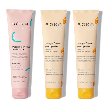 Three tubes of Boka toothpaste, two in orange cream flavor and one in watermelon mint flavor, on a white background.