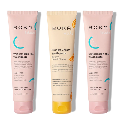Three tubes of Boka toothpaste, two pink and one orange, on a white background.