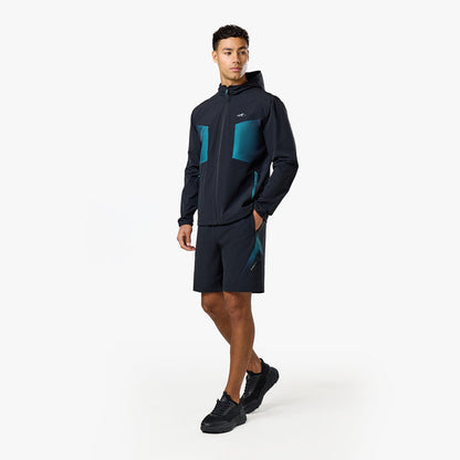 Model is wearing the black and teal shorts and windbreaker from the Closure tri-set