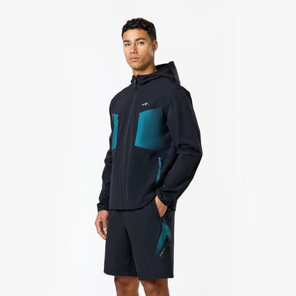 The model is wearing a teal detailed zip up windbreaker and black shorts with closure logo