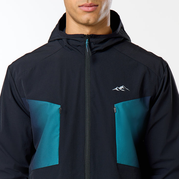 The model shows a close up of the Closure black and teal windbreaker with pocket details and Closure logo