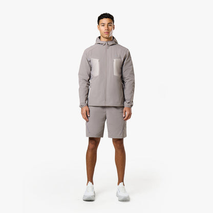 Model is wearing grey tri-set with hooded grey windbreaker with pockets and matching grey shorts