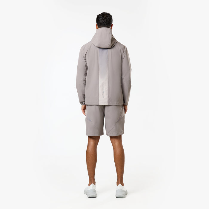 Model is showing the gradient stripe on the back of the tri-set windbreaker and grey shorts