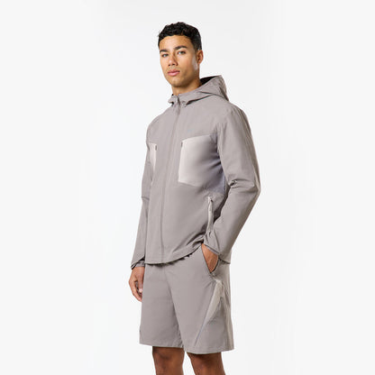 Model is wearing the closure grey and white detailed windbreaker and matching shorts