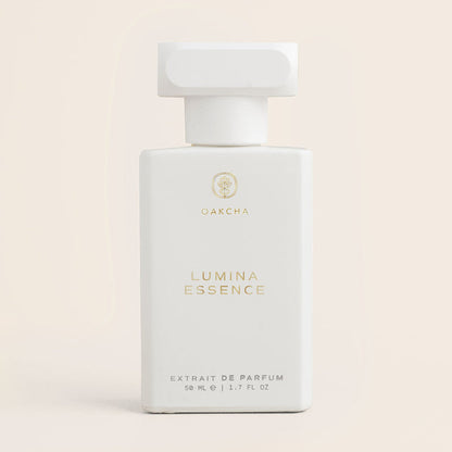 Front view of Lumina Essence 50 ml perfume bottle showing matte white rectangular bottle with gold Oakcha logo and large cap on pale beige background