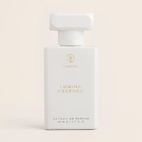 Front view of Lumina Essence 50 ml perfume bottle showing matte white rectangular bottle with gold Oakcha logo and large cap on pale beige background