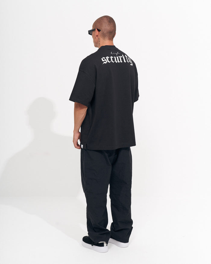 Martin Valen men's black baggy pant, tight side view of leg and ankle, straight hem with sneakers visible
