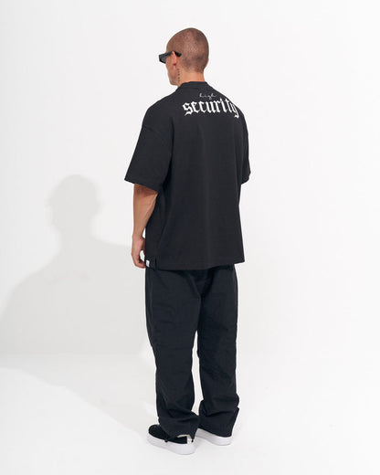 Martin Valen men's black baggy pant, tight side view of leg and ankle, straight hem with sneakers visible