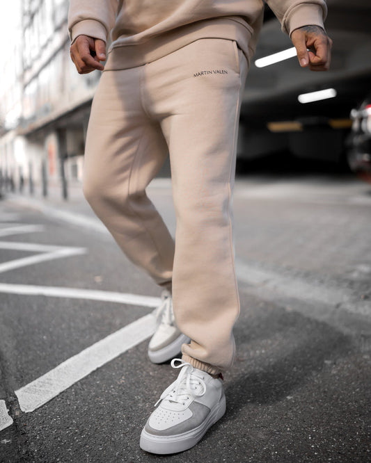 Martin Valen MV Basic beige jogger three-quarter low view, black logo on pocket and elastic cuff visible
