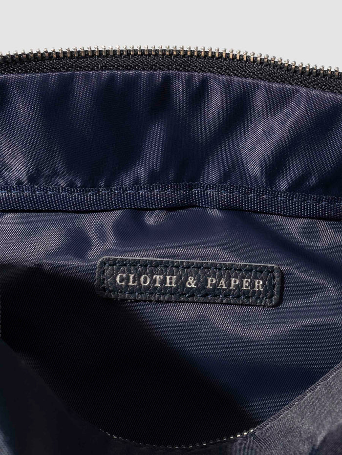 Closeup of interior of bag. A vegan leather tag is inside the bag with "Cloth & Paper" stamped on it with silver foil.