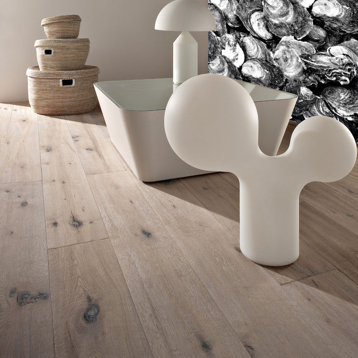 Modern interior with a white abstract sculpture on a wooden floor, a lamp, and woven baskets.