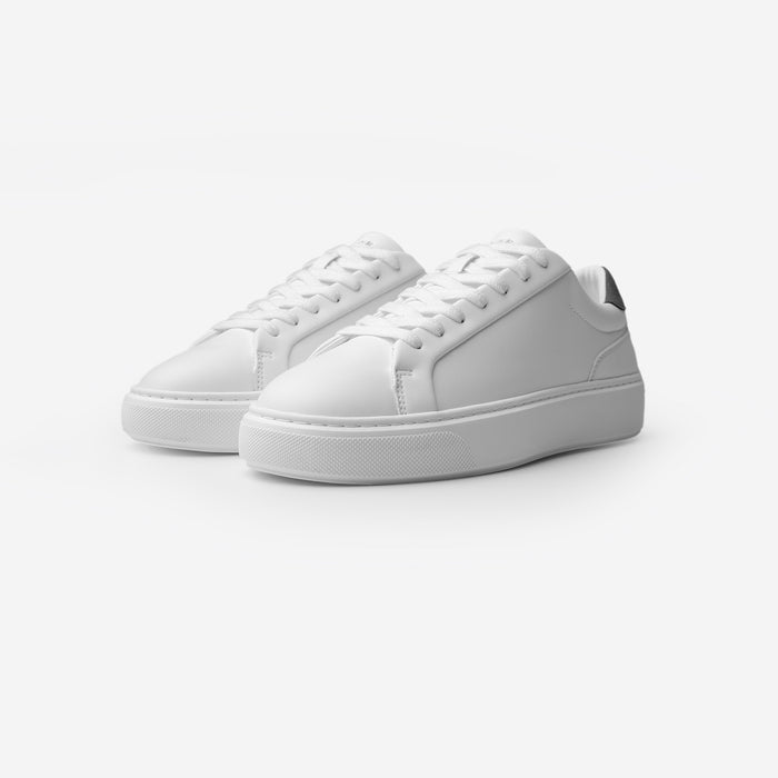 Three-quarter view of the Premium Classic Trainers in White/Grey, featuring clean white PU uppers, white lace-up fastening, grey faux suede heel panels and cushioned cup soles.