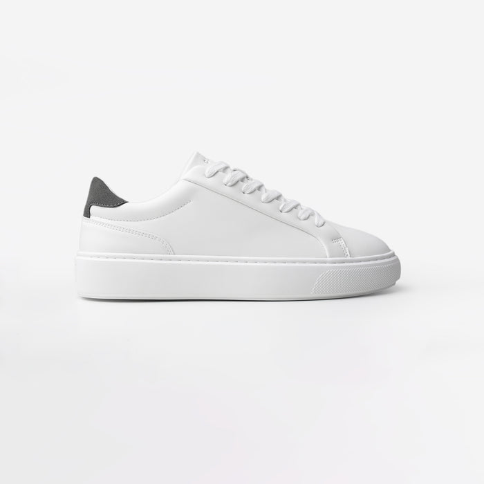 Side view of the Premium Classic Trainer in White/Grey, featuring a white PU upper, grey faux suede heel, white lace-up fastening and lightweight cushioned cup sole.