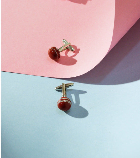 Red dome stone cufflinks with silver-tone bar backs and green detailing