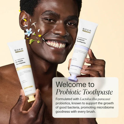 Man holding Boka Probiotic Toothpaste with a message on a beige background