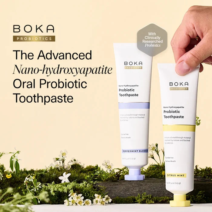 Boka Probiotics toothpaste tubes with a hand holding one, set against a natural background.