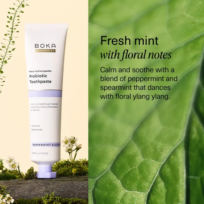Boka Probiotic Toothpaste with a green leaf background and text about mint and floral notes.