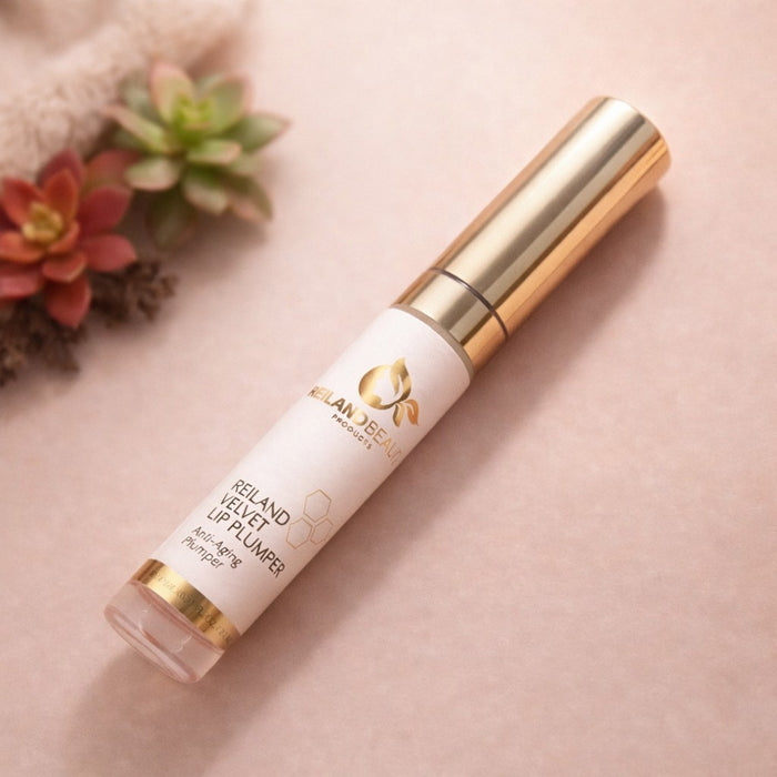Reiland Velvet Lip Plumper displayed in a flat lay with succulent plants on a soft peach background.