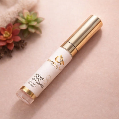 Reiland Velvet Lip Plumper displayed in a flat lay with succulent plants on a soft peach background.