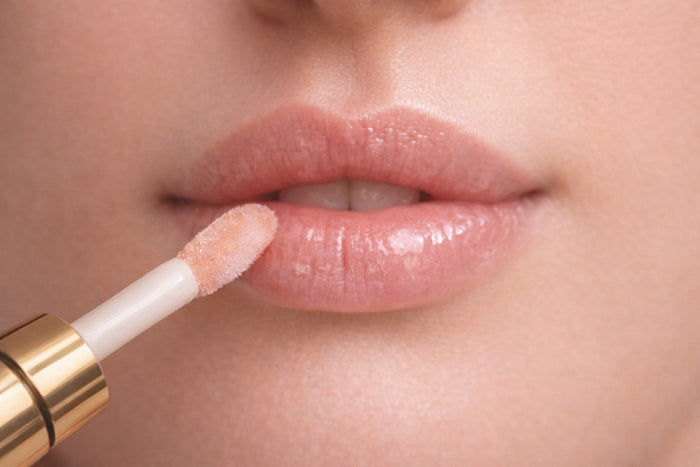Applicator applying Reiland Velvet Lip Plumper to lips in a close-up application shot with a natural finish.