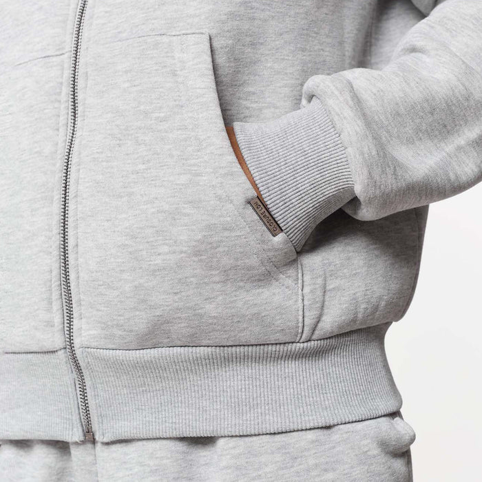 Model's hand in kangeroo pocket showcasing branded detailing
