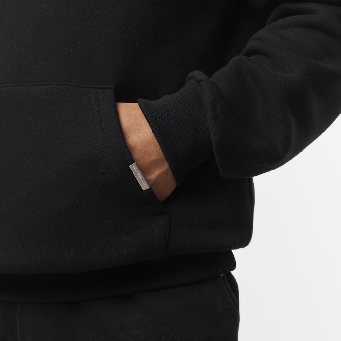 Close pup of models hand in kangaroo pocket with branded detailing