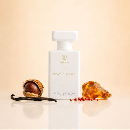 Front view of Static Bond perfume bottle showing white bottle with vanilla bean and amber on beige background