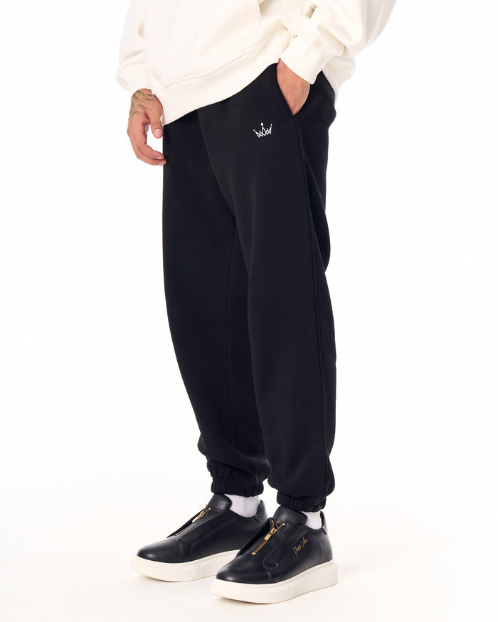 Martin Valen The Crown oversized black jogger, three-quarter front view showing white crown logo and elastic cuffs