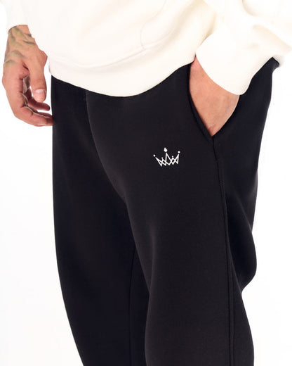 Martin Valen The Crown oversized black jogger, front view showing side pocket, elastic ankle and black sneakers