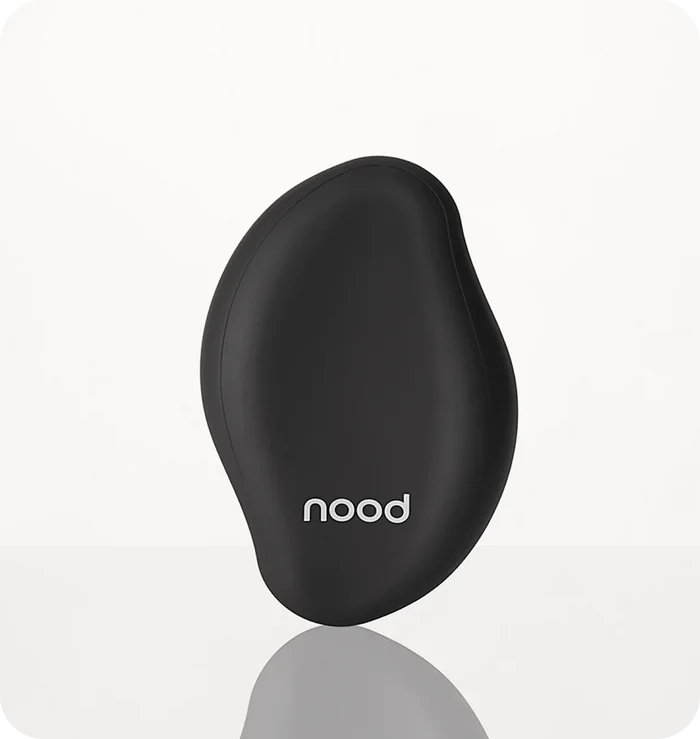 Nood The Eraser IPL hair removal device in black on a light grey background with reflection
