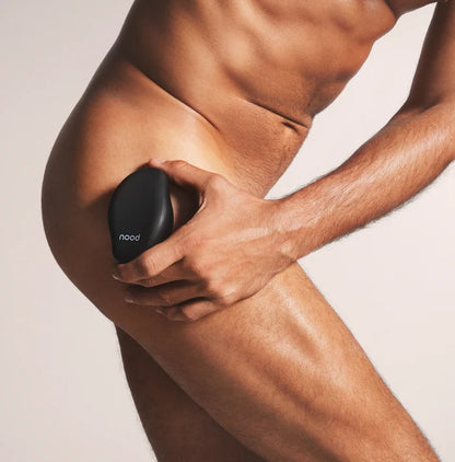 Man using black Nood Eraser exfoliating hair removal tool on upper thigh and hip area