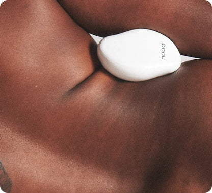 Woman using white Nood Eraser exfoliating hair removal tool on upper back and shoulder area