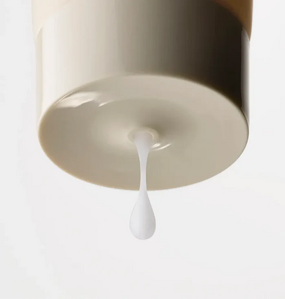 Close-up of Nood The Shave Lube tube cap with a drop of white lubricant formula dripping from the nozzle