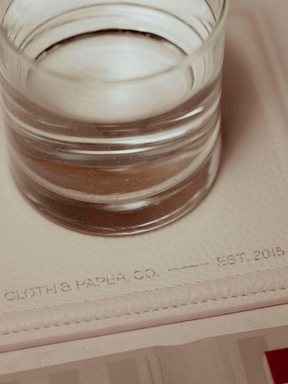 Trinket tray displayed on a neutral backdrop. A cup of water is placed on top of it.