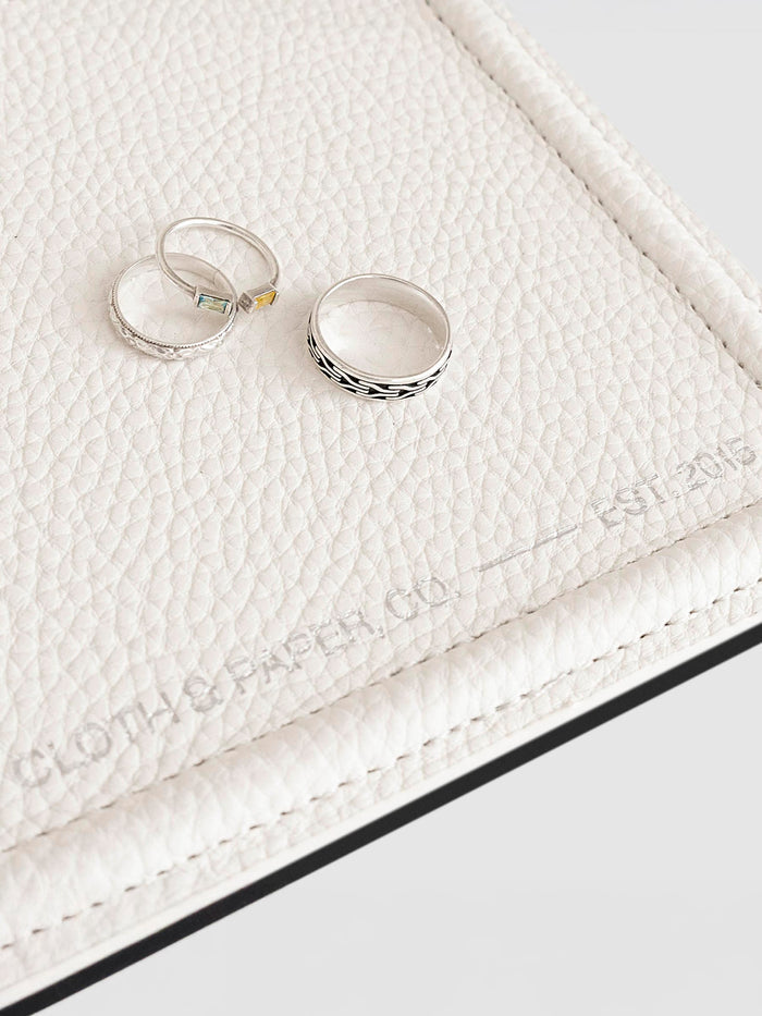 Closeup of tray shown with three silver rings displayed inside it.